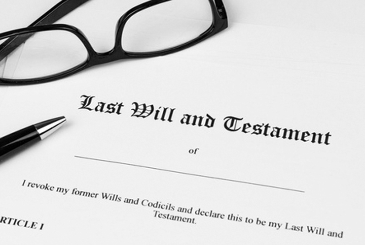 Close-up of a Last Will and Testament document with a pen and glasses, representing making a Will and estate planning.